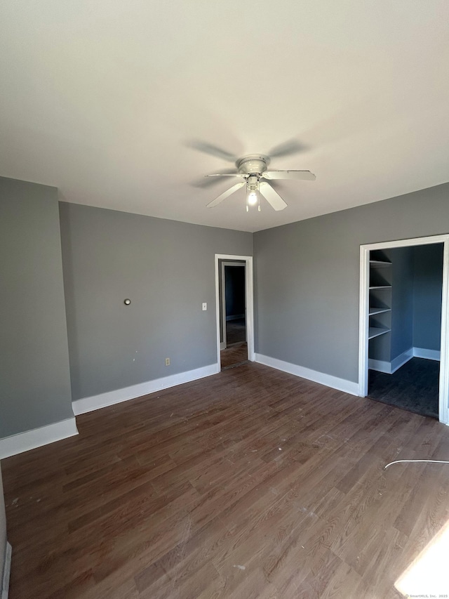 empty room featuring ceiling fan, baseboards, and wood finished floors