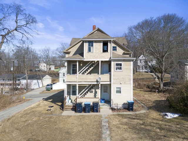 rear view of property featuring a chimney and entry steps