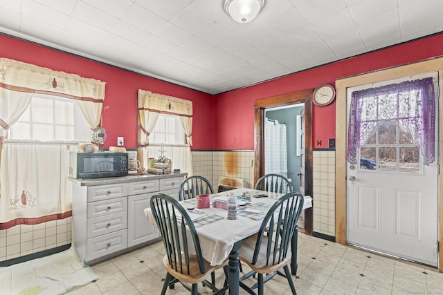 dining area with tile walls and wainscoting