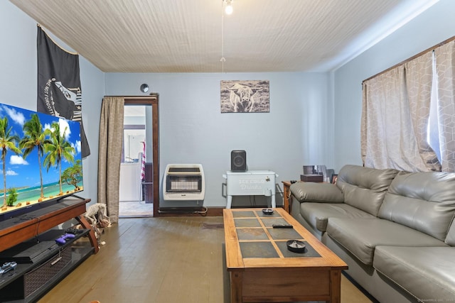 living area with heating unit and wood-type flooring