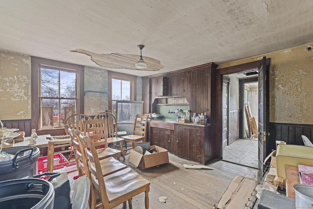 dining space featuring light wood-style flooring and wainscoting