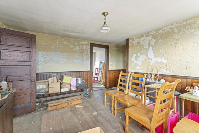 dining room with a wainscoted wall, hardwood / wood-style floors, and wood walls