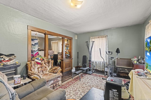 living room featuring decorative columns and a textured ceiling