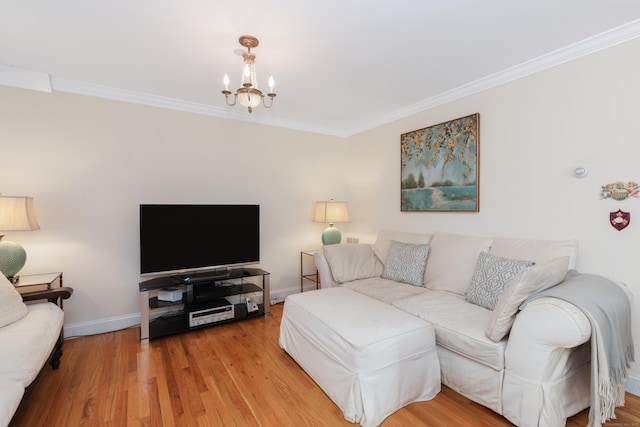 living room featuring ornamental molding, baseboards, a chandelier, and wood finished floors