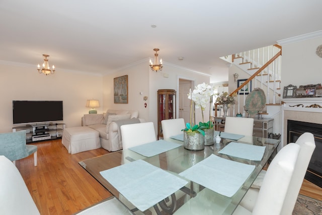 dining room with a notable chandelier, ornamental molding, and stairway