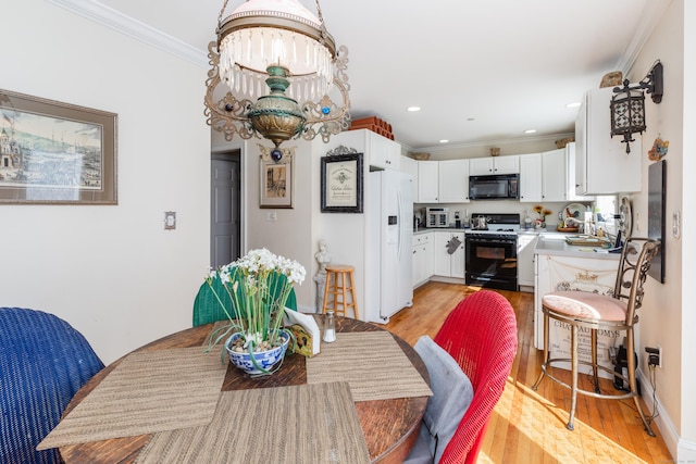 dining area with recessed lighting, light wood-style flooring, and ornamental molding