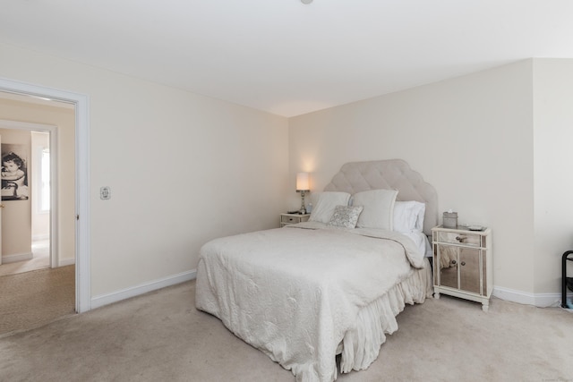 bedroom with light carpet and baseboards