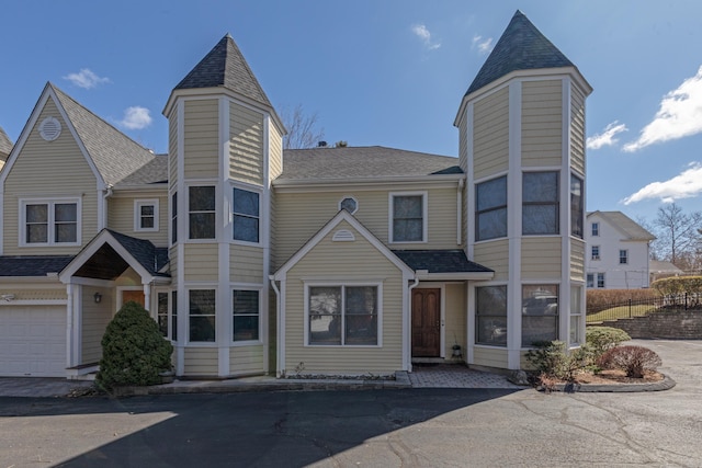 view of front of house with a shingled roof and fence