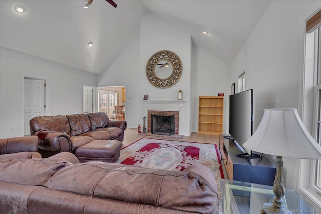 living room featuring a fireplace, light wood-style floors, and high vaulted ceiling