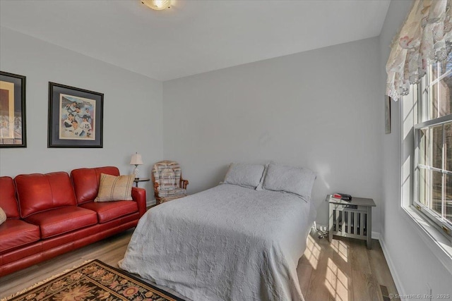 bedroom featuring wood finished floors and baseboards