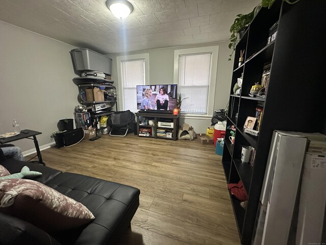 living area featuring baseboards and wood finished floors