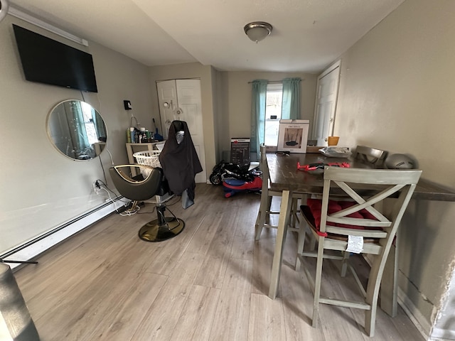 dining space with wood finished floors and a baseboard heating unit