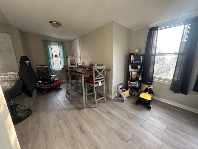 dining space with baseboards and wood finished floors