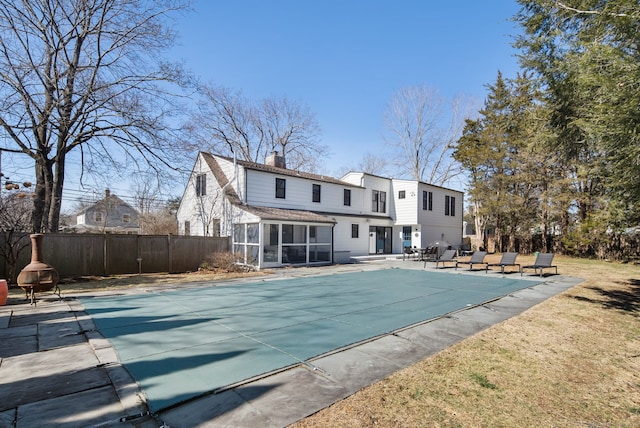 view of swimming pool with a fenced in pool, fence, a patio area, and a sunroom