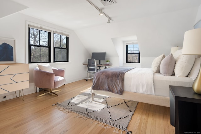 bedroom featuring light wood finished floors, visible vents, and multiple windows