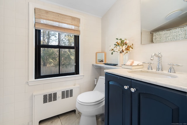 bathroom with toilet, radiator heating unit, tile walls, lofted ceiling, and vanity