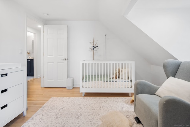 bedroom featuring light wood-style floors and vaulted ceiling