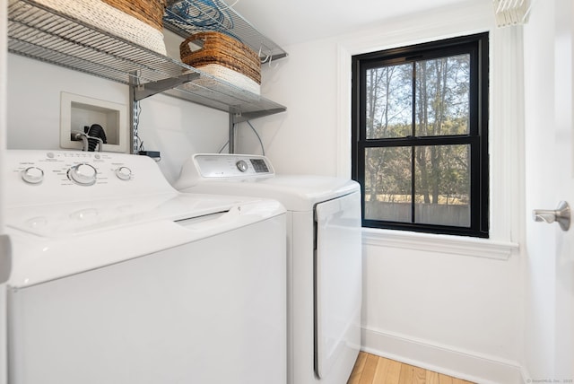 laundry area featuring a wealth of natural light, laundry area, independent washer and dryer, and light wood-type flooring