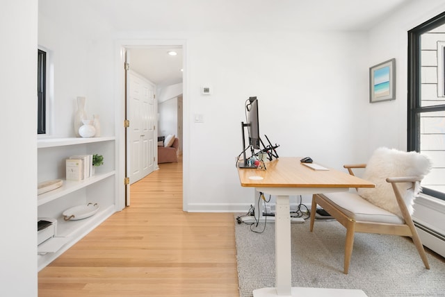 office area with baseboards and light wood-type flooring