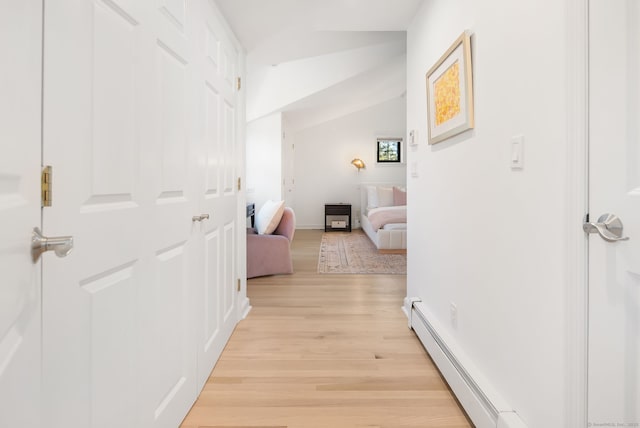 hallway featuring vaulted ceiling and light wood-style floors