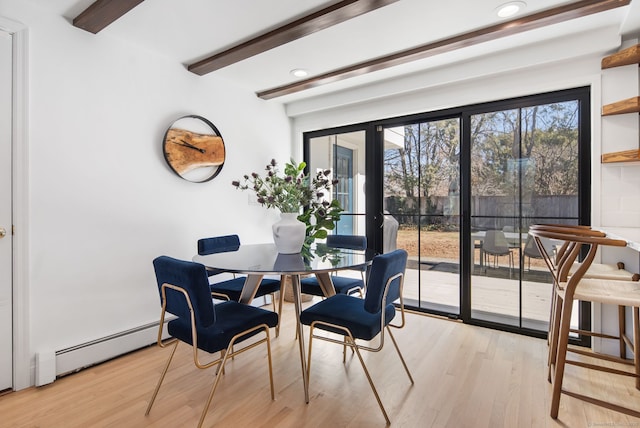 dining space featuring a baseboard heating unit, beamed ceiling, and light wood-type flooring