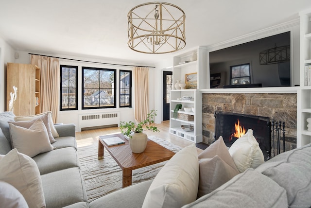 living area with built in features, a fireplace, wood finished floors, and radiator heating unit