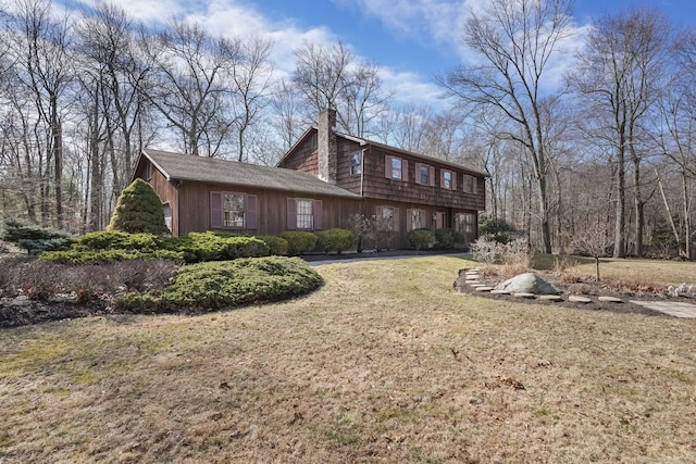 view of side of property featuring a chimney and a yard