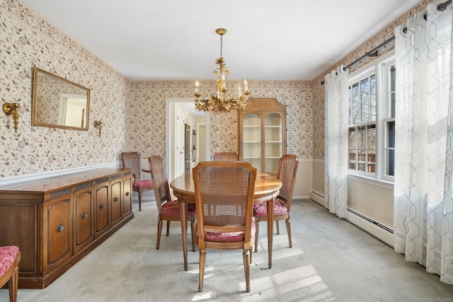 dining area with light colored carpet, a chandelier, wainscoting, and wallpapered walls