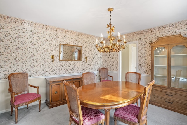 dining space featuring baseboards, light carpet, an inviting chandelier, and wallpapered walls