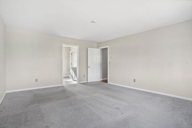 spare room featuring baseboards, baseboard heating, and carpet floors