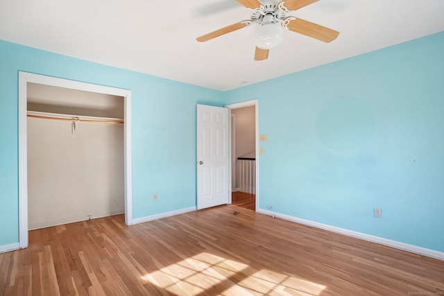 unfurnished bedroom featuring ceiling fan, a closet, baseboards, and wood finished floors