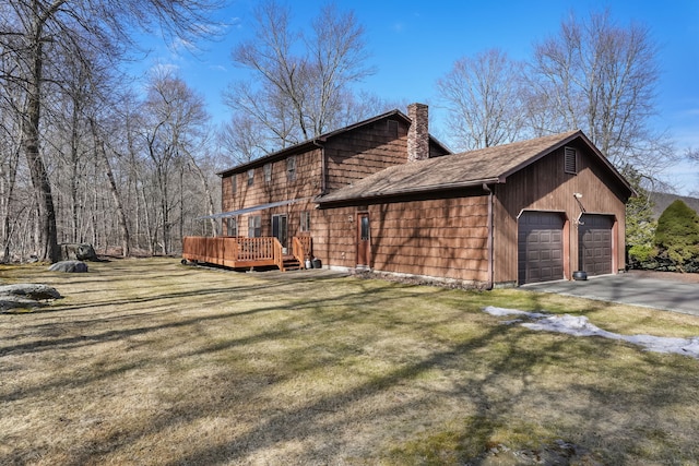 view of property exterior with a lawn, a chimney, a deck, a garage, and driveway