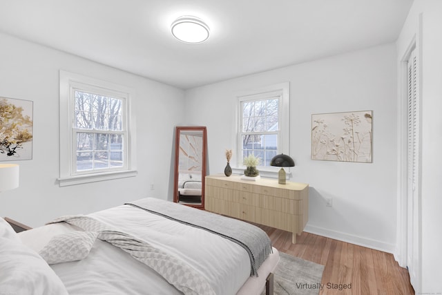 bedroom with light wood-style flooring and baseboards