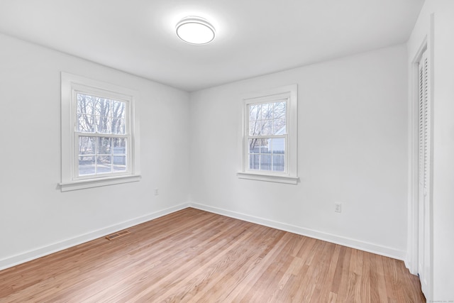 unfurnished room featuring visible vents, baseboards, and light wood-style flooring