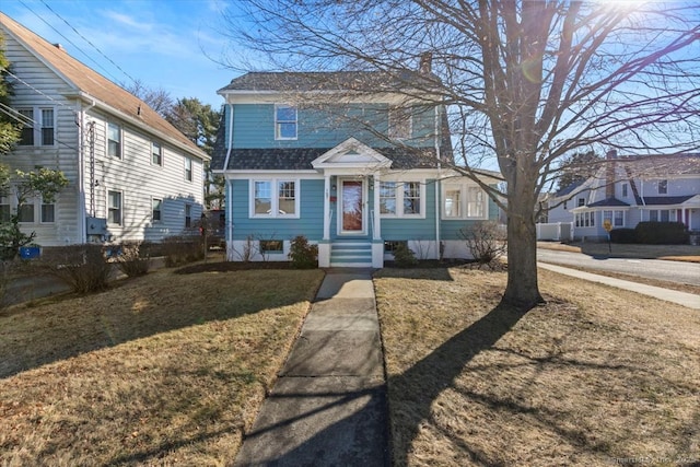 view of front of property with a shingled roof, a front yard, and entry steps