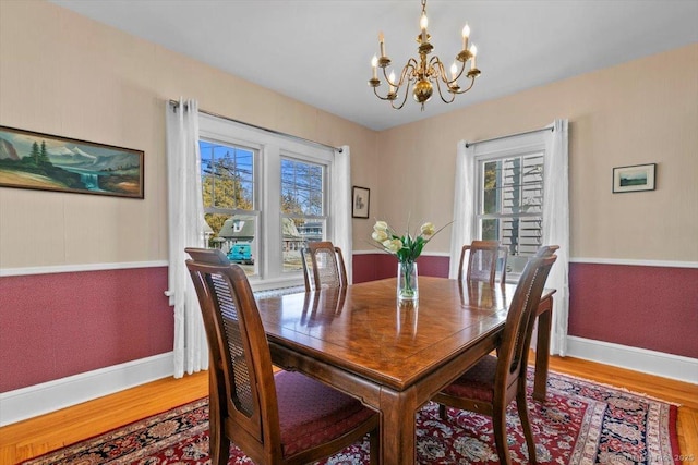 dining space with a chandelier, baseboards, and wood finished floors