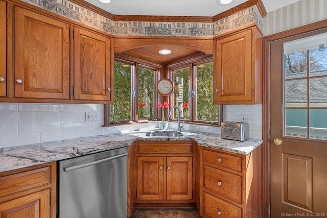 kitchen with brown cabinets, dishwasher, and a sink