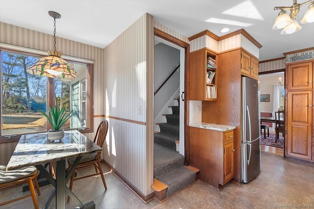 dining area with wallpapered walls, stairway, and a notable chandelier