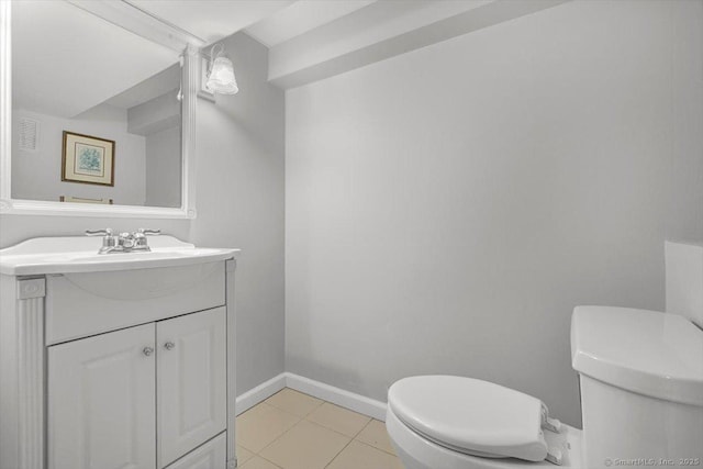 bathroom with baseboards, toilet, vanity, and tile patterned flooring