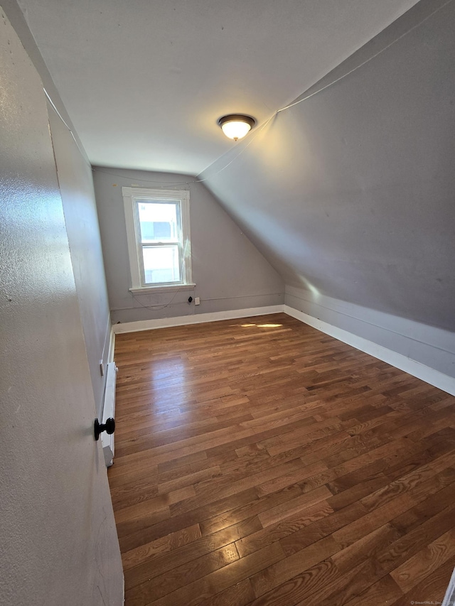 bonus room with vaulted ceiling, wood finished floors, and baseboards