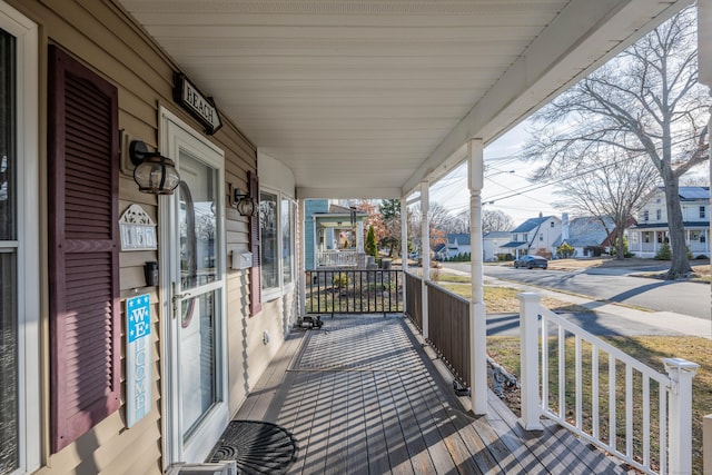 wooden deck featuring covered porch and a residential view