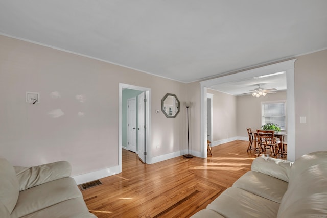 living room featuring parquet flooring, visible vents, crown molding, and baseboards