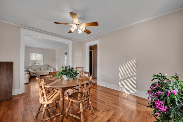 dining area featuring crown molding, parquet flooring, baseboards, and ceiling fan