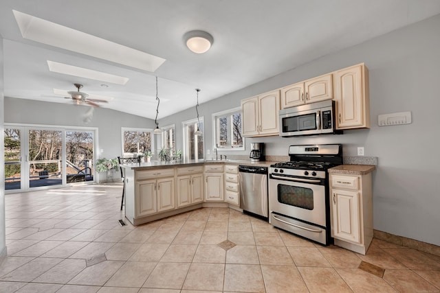 kitchen with lofted ceiling with skylight, a ceiling fan, a peninsula, appliances with stainless steel finishes, and light tile patterned flooring