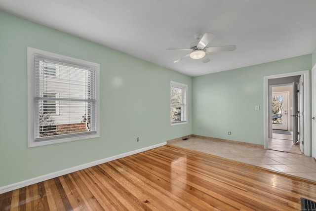 empty room featuring visible vents, light wood-style flooring, and baseboards