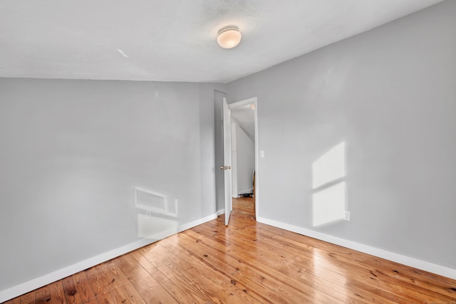 unfurnished room featuring baseboards and light wood-style floors