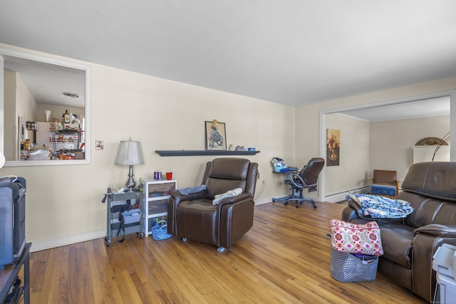 living room with a baseboard heating unit, baseboards, and hardwood / wood-style floors