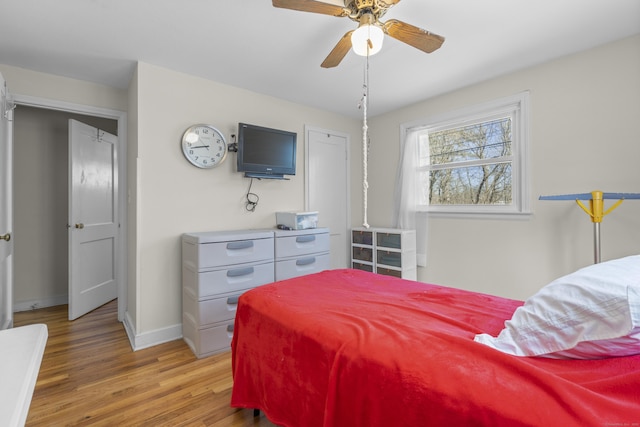 bedroom with baseboards, light wood-style floors, and a ceiling fan