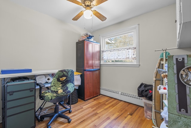 office space featuring baseboard heating, light wood-style flooring, and a ceiling fan