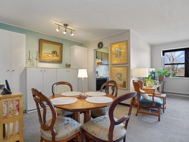 carpeted dining area with a baseboard radiator